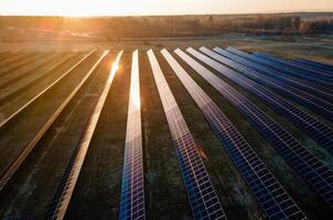 Aerial view of industrial sized solar panel farm during sunset, illustrating the blend of technology and nature photo