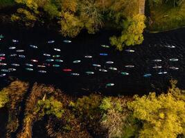 aerial view of stand up paddle board competition on a river with colorful boards and lush green surroundings on a summer day photo