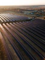 Aerial view of industrial sized solar panel farm during sunset, illustrating the blend of technology and nature photo