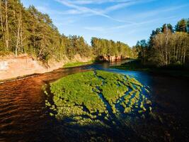 aerial view of the striking red cliffs and lush forests along a curving river Salaca in latvia photo