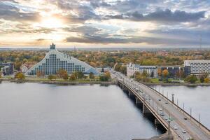 Panoramic view with Akmens Bridge over Daugava River and National Library of Latvia in Riga at sunset in autumn photo