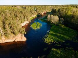 aerial view of the striking red cliffs and lush forests along a curving river Salaca in latvia photo