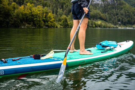 Man Paddling in an Alpine Lake, Enjoying the Mountain Scenery, Inflatable SUP Board Adventure photo