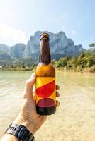Colorful beer bottle with mountains in the background. Space for text and logo photo