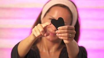 Girl shows Gua Sha on camera close up video