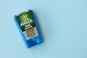 KYIV, UKRAINE - APRIL 20, 2024 Halls mini mints mint twist energy vitamin b6 small blue case with hard mints inside on blue background photo