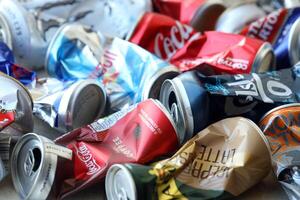 KYIV, UKRAINE - APRIL 20, 2024 Background of various crashed beer cans. Recycle aluminum metal crushed tin can waste photo