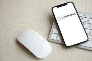 KYIV, UKRAINE - MARCH 17, 2024 Synthesia logo on iPhone display screen with apple keyboard and mouse on table photo