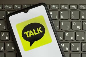 KYIV, UKRAINE - APRIL 1, 2024 KakaoTalk messenger icon on smartphone screen on black keyboard photo