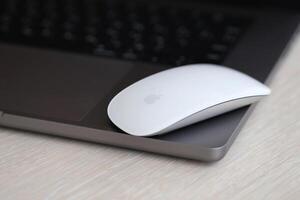 KYIV, UKRAINE - NOVEMBER 27, 2023 Apple Magic Mouse 3rd generation lies with grey MacBook 2021 photo
