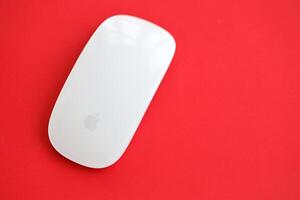 KYIV, UKRAINE - NOVEMBER 27, 2023 Apple Magic Mouse 3rd generation lies on bright colored background photo