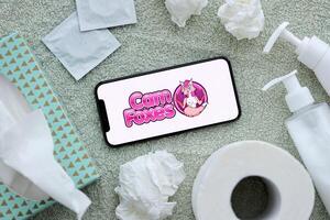 KYIV, UKRAINE - JANUARY 23, 2024 CamFoxes adult content website logo on display of iPhone 12 Pro photo