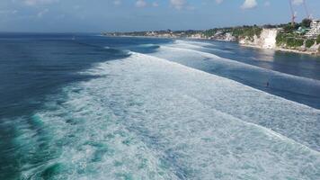 Drone view of coastline with cliffs and ocean with surfing waves in Bali, Impossible beach video