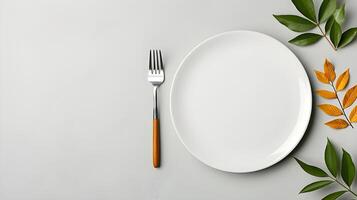 Top down view of a white plate isolated on yellow background with fork and knife with copy space photo