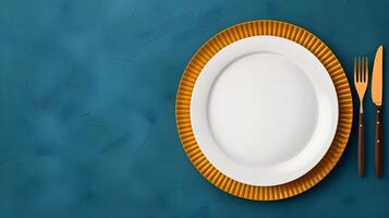 Top down view of a white plate isolated on yellow background with fork and knife with copy space photo