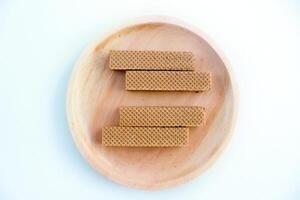 Chocolate waffles on wooden plate isolated on white background. Crispy snack dessert. Food Photography Concept photo