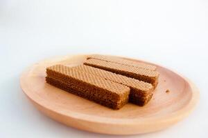 Chocolate waffles on wooden plate isolated on white background. Crispy snack dessert. Food Photography Concept photo