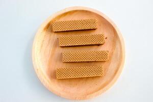Chocolate waffles on wooden plate isolated on white background. Crispy snack dessert. Food Photography Concept photo
