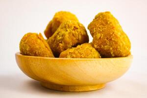 Tahu goreng cripsy, or crispy fried tofu, is one type of snack in Indonesia on wood plate isolated on white background. Perfect for recipe, article, catalogue, commercial, or any cooking contents photo