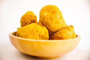 Tahu goreng cripsy, or crispy fried tofu, is one type of snack in Indonesia on wood plate isolated on white background. Perfect for recipe, article, catalogue, commercial, or any cooking contents photo