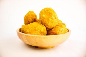 Tahu goreng cripsy, or crispy fried tofu, is one type of snack in Indonesia on wood plate isolated on white background. Perfect for recipe, article, catalogue, commercial, or any cooking contents photo