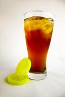 Iced tea with lemon and ice in a tall glass on a white background. The concept of a refreshing drink or lemonade on a hot summer day. Front view and copy space. photo