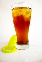 Iced tea with lemon and ice in a tall glass on a white background. The concept of a refreshing drink or lemonade on a hot summer day. Front view and copy space. photo
