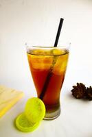 Iced tea with lemon and ice in a tall glass on a white background. The concept of a refreshing drink or lemonade on a hot summer day. Front view and copy space. photo
