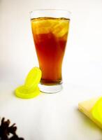 Iced tea with lemon and ice in a tall glass on a white background. The concept of a refreshing drink or lemonade on a hot summer day. Front view and copy space. photo