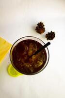 Iced tea with lemon and ice in a tall glass on a white background. The concept of a refreshing drink or lemonade on a hot summer day. Front view and copy space. photo