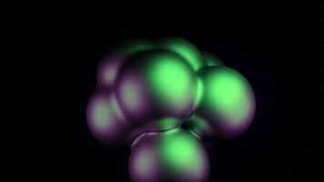 Abstract spheres of green and and purple spheres pulsating on a black background. Design. Glowing balls stick together and break apart. video
