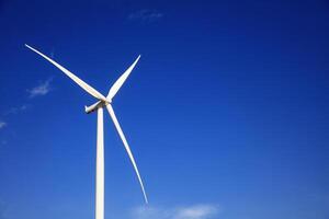 the propeller of wind turbine against the blue sky and cloudy in background photo