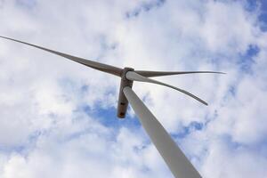 the propeller of wind turbine against the blue sky and cloudy in background photo