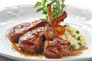 rack of lamb and cheese risotto on plate photo