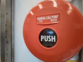 Manual call point tool for fire alarm system, red installed on the wall photo