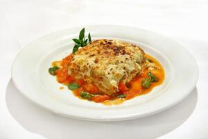 Bolognese lasagna with basil on plate photo