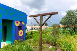 Fazendas do Cortico, Alentejo, Portugal. April 20, 2024. A rustic washhouse at fazendas do Cortico, with vibrant modern art painted on its weathered walls. photo