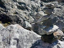 pyramid of balanced stones. natural rock wall background with rough texture. Abstract backdrop with copy space photo
