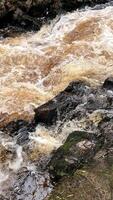vertical photo of a stormy river and huge rocks. abstract wallpaper with natural theme and materials
