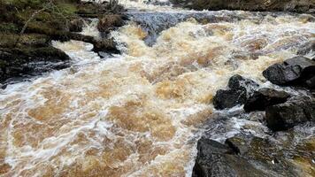 Close up of river stream on stones. Aerial view of the waves and rapids of the wild river. abstract nature background photo