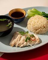 Hainanese chicken rice is a dish consisting of delicious steamed white chicken cut into pieces and served over fragrant rice photo