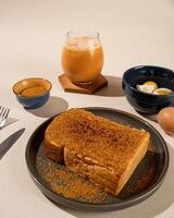 Roti Bakar is a typical grilled Indonesian sandwich, consisting of two slices of bread and filling, served with Teh Tarik and boiled egg. photo