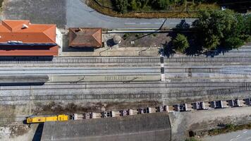 Aerial view of Portalegre railway station, featuring the word Portalegre spelled out in stone on the platform, with cargo wagons visible on the tracks. photo