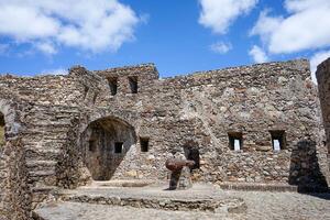 Marvao, Portugal. May 19, 2024. Battlements of Marvao Castle with old cannons pointing toward the scenic landscape, capturing history and panoramic views in a display of medieval defense architecture. photo