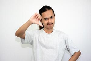 Upset and angry man with hand thumb pointing down, isolated on white background. photo