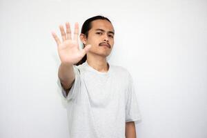 Annoyed and angry man raises hand and says no, looking at camera angrily isolated on white background photo