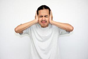 The Asian man was very upset and covered both ears with both hands. white isolation background photo