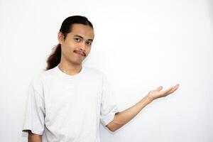 Asian man in gray tshirt pointing to the side. isolated on white studio background. Asian man with long hair photo
