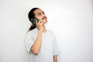 Asian man with a happy expression while receiving an incoming call from his cell phone. isolated in white background photo