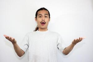 Shocked Asian man standing while presenting something in front of him. Isolated on white with copy space photo